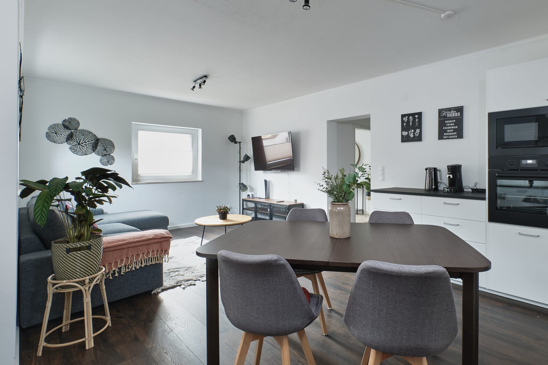 Open-plan living room with dining area and kitchen in Mumo's Inn TLA apartment